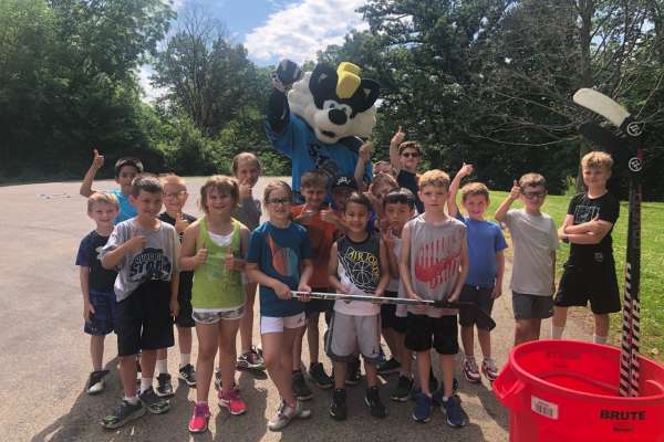 A group of kids with the Quad City Storm mascot