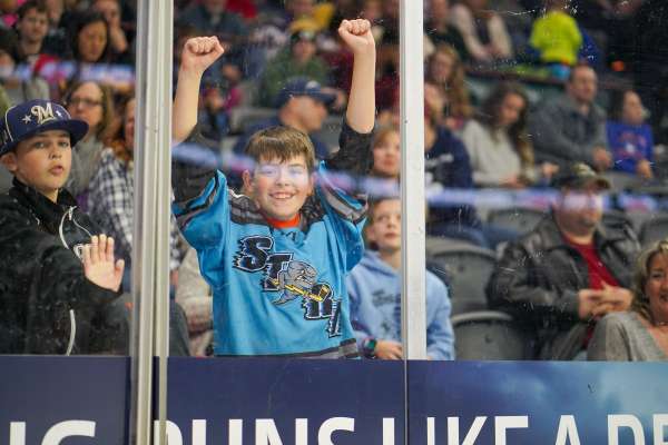 Fans standing behind the protective screen